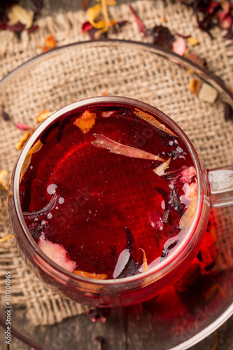 Cup of fresh red tea on wooden background