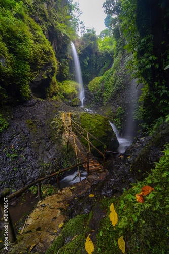 Beautiful waterfalls of tropical forest. Waterfalls with bridge. Curug Aseupan, Bandung west java Indonesia. Vertical orientation for smartphone wallpaper or background. 