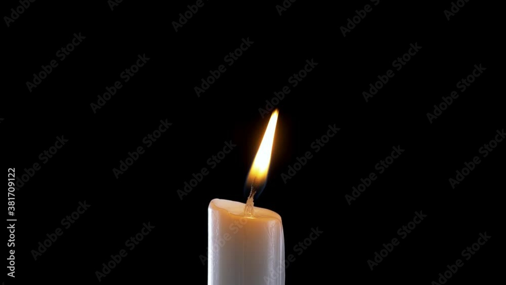 A single white candle burning.Isolated candle burning with dark background.White paraffin candle with yellow shades burns on a black background.Background or illustration of remembrance or celebration A single white candle burning.Isolated candle burning with dark background.White paraffin candle with yellow shades burns on a black background.Background or illustration of remembrance or celebration
