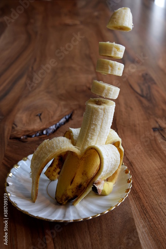 Banana slices lavitating above a wooden table. Banana levitation. photo