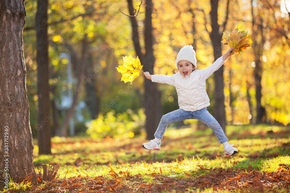 Happy girl playing yellow leaves in the autumn park. Beauty nature scene with family outdoor lifestyle. Happy girl having fun outdoor. Happiness and harmony in childhood - obrazy, fototapety, plakaty 