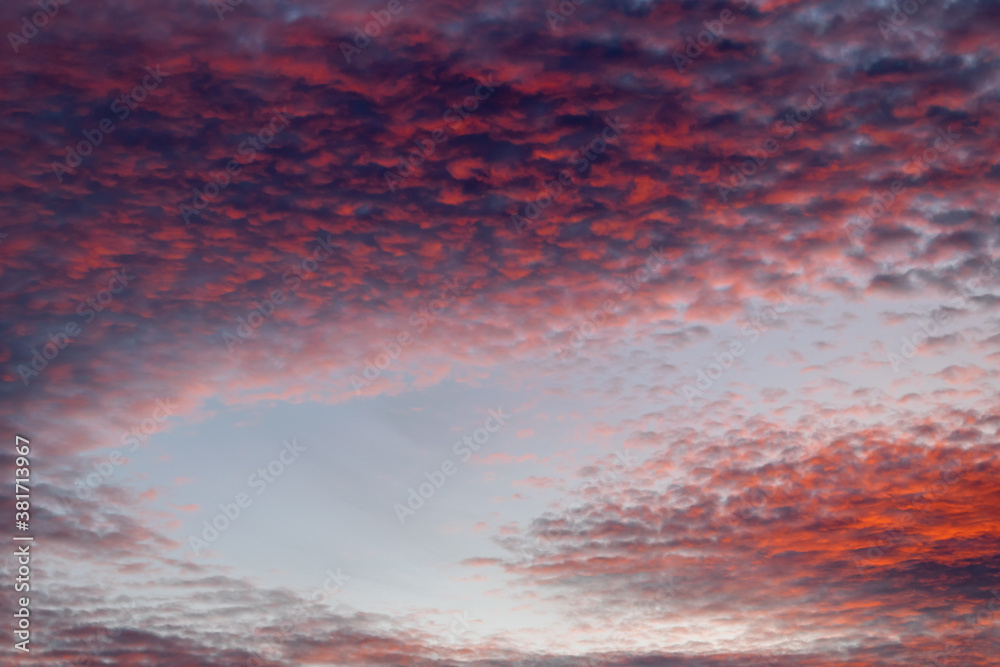 Fototapeta premium a swooping blue sky surrounded by golden clouds during sunset in Marbella, Spain 