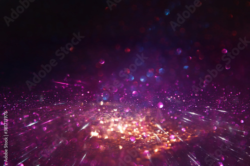 background of abstract glitter lights. gold, black and purple. de focused