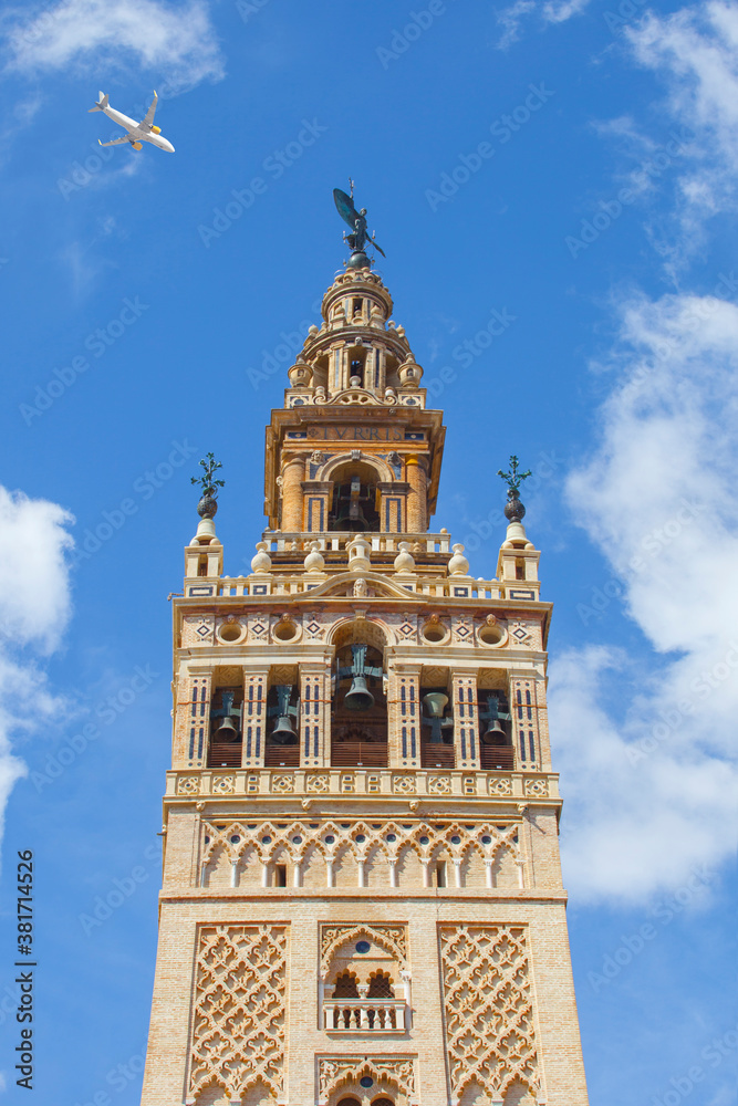 Passenger airliner overThe Giralda Tower, Seville, Spain