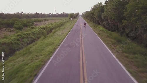 Chasing and passing a motorcycle on a straight road. photo