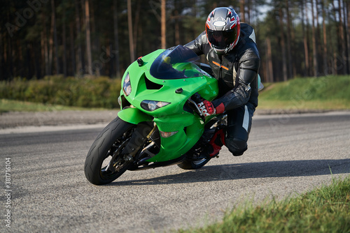 Handsome motorcyclist riding his super sport motorcycle.  Moto racing. MotoGP. Super bikes. Green motorcycle