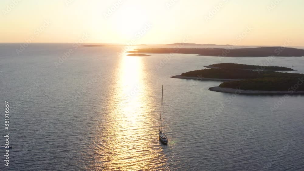 Sailboat Sailing In The Adriatic Sea With Beautiful Reflections Of Sunlight Reflecting On The Surface Near The Losinj Island In Croatia. - aerial arc shot Sailboat Sailing In The Adriatic Sea With Beautiful Reflections Of Sunlight Reflecting On The Surface Near The Losinj Island In Croatia. - aerial arc shot