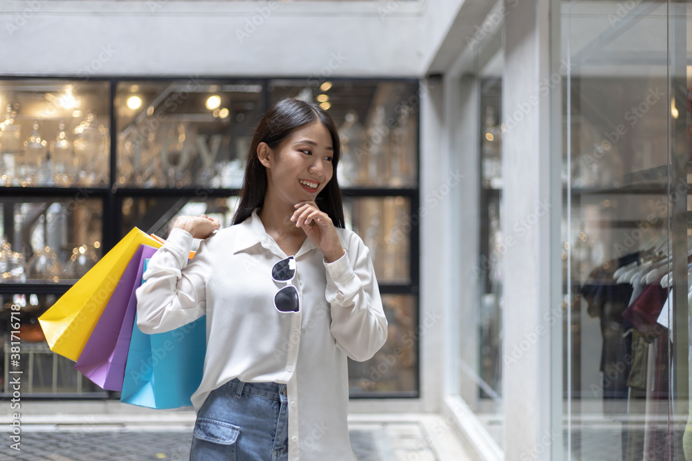Asian woman sit rested after shopping in a colorful bag and she was happy to go shopping