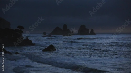 The wild west coast of new Zealand. Rock formations in a dark stormy mood at dusk at Motukiekie Beach photo