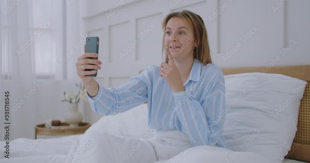 Businesswoman having a video call in hotel. Happy girl lies on the bed, talks with friends via video call. Businesswoman having a video call in hotel. Happy girl lies on the bed, talks with friends via video call.