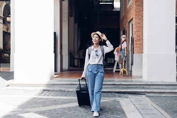 Asian woman beaming carrying a suitcase black to travel on vacation, Trolley bag, Long weekend travel, Love the trip, Tourism festival concept.