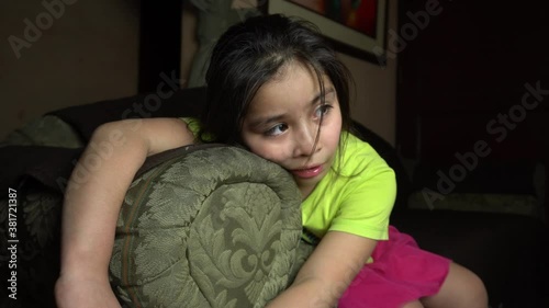 a girl sitting on the couch watching tv and drooling