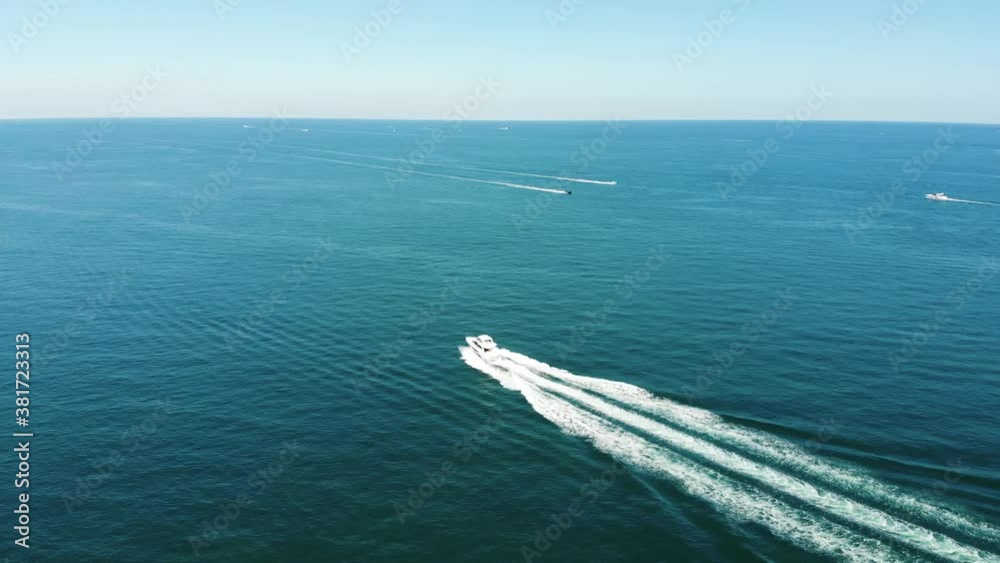 Boats out on the vast open ocean creating white water splash on beautiful sunny day Boats out on the vast open ocean creating white water splash on beautiful sunny day