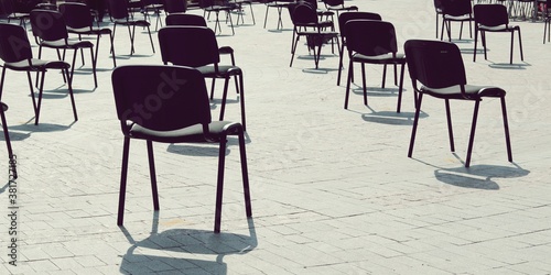 Chairs on the street are arranged in rows at a distance  keep your distance  quarantine measures  preparation for a conference  a concert