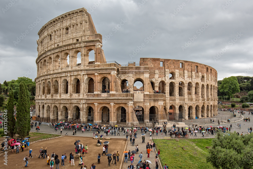 Tourists Visiting the Colosseum (Flavian Amphitheatre)  in Rome. The Colosseum is a major tourist attraction in Rome, Italy
