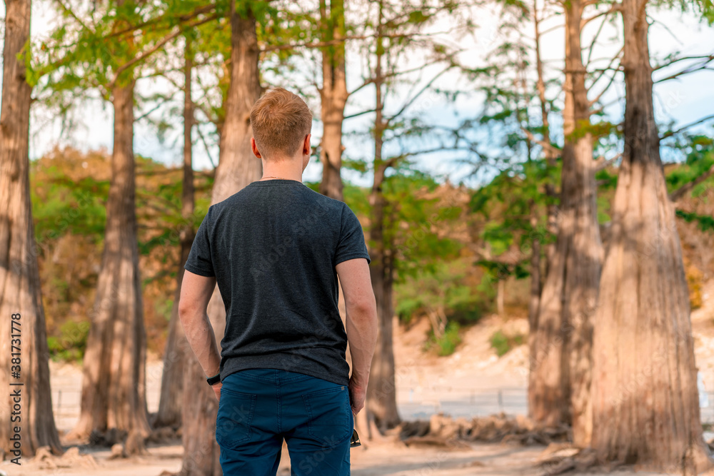Young male tourist in cypress grove growing in Sukko lake