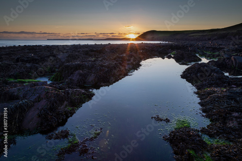 Rockpools at sunset on Manorbier beach in West Wales, UK
