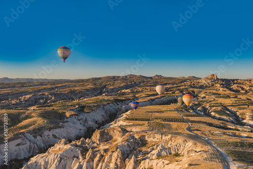 Hot air balloons flying over rock landscape at sunrise, Cappadocia, Turkey