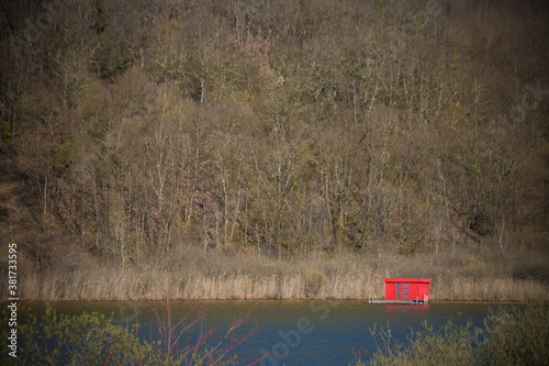 cabane flottante rouge au milieu d'un lac en hiver © jef 77