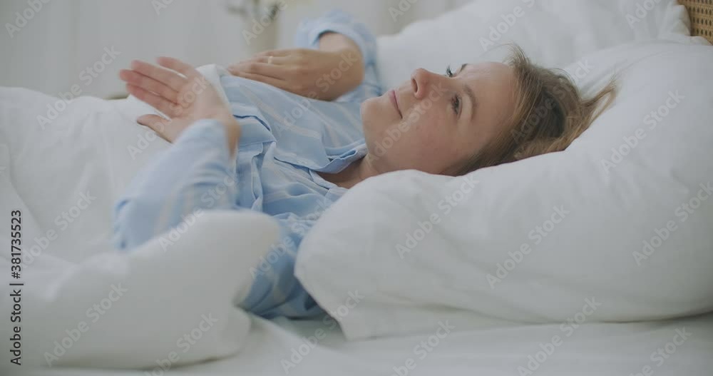 A close-up of a beautiful young woman's face. She is awakening after the sleep. Her hair is on the pillow. A close-up of a beautiful young woman's face. She is awakening after the sleep. Her hair is on the pillow.