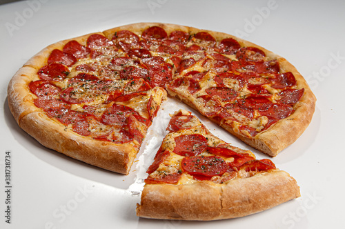 Pepperoni pizza slice on white background. Copy space. Selective focus