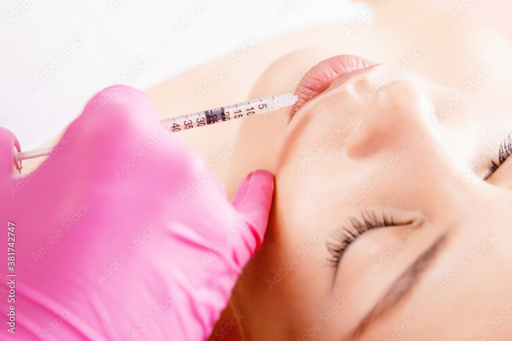 Augmentation form of lips. Beautiful young woman mouth receiving hyaluronic acid injection Augmentation form of lips. Beautiful young woman mouth receiving hyaluronic acid injection