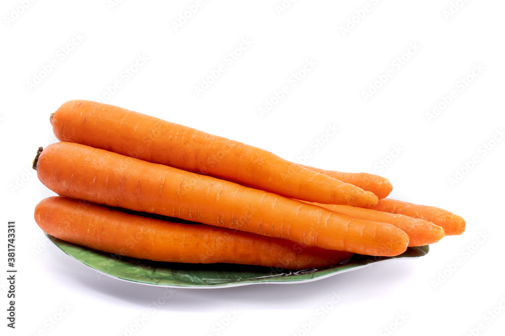 a natural looking bunch of carrots with slight imperfections on a green plate isolated on white a natural looking bunch of carrots with slight imperfections on a green plate isolated on white