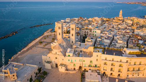 Beautiful panoramic aerial view photo from flying drone on Molfetta waterfront with the Old Cathedral San Corrado (Duomo Vecchio),port with ships and yachtsand the Molfetta city sunset. Apulia ,Italy