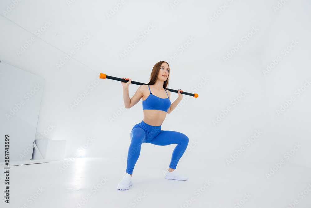Sexy young girl performs sports exercises on a white background. Fitness, healthy lifestyle Sexy young girl performs sports exercises on a white background. Fitness, healthy lifestyle