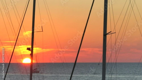 Beautiful sunset over the see in motion with masts of yachts in the foreground. 4k. Time lapse