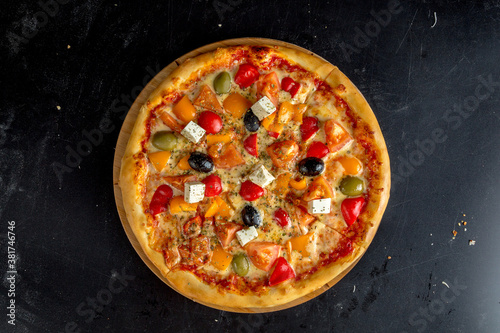 Greek pizza with olives, bell peppers, feta cheese and tomatoes.