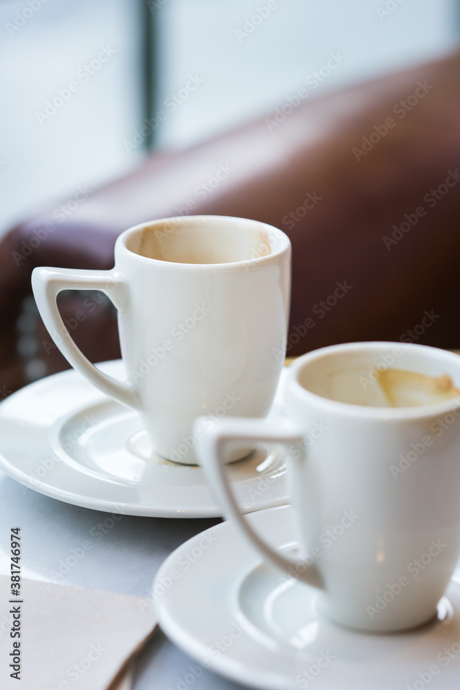 Two empty coffee cups on a table in a cafe Two empty coffee cups on a table in a cafe