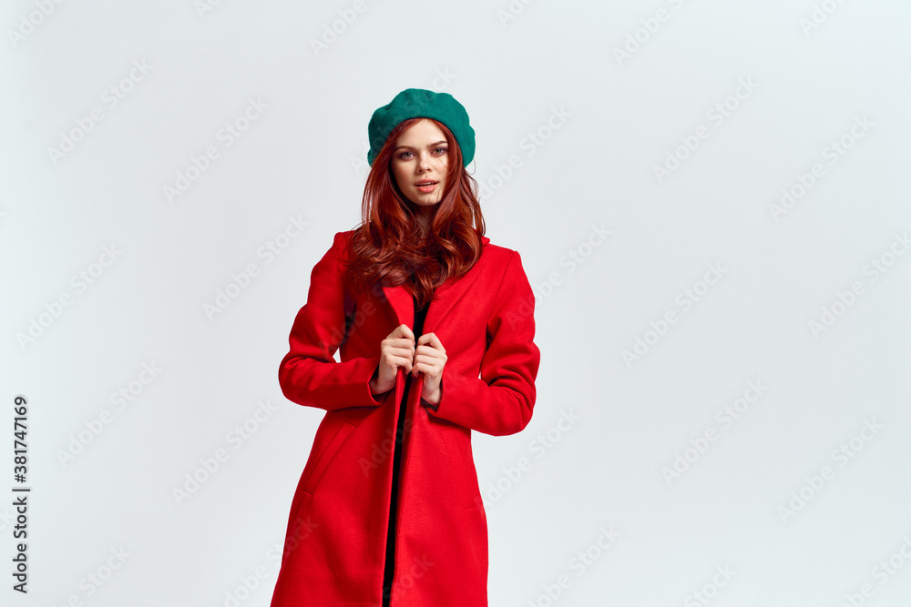 Portrait of a woman in a red coat and in a green hat dark clothes light background model cropped view Portrait of a woman in a red coat and in a green hat dark clothes light background model cropped view