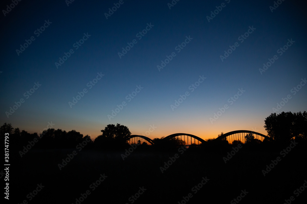silhouette of old bridge in the late evening sunset in Bałobrzegi, Poland.
