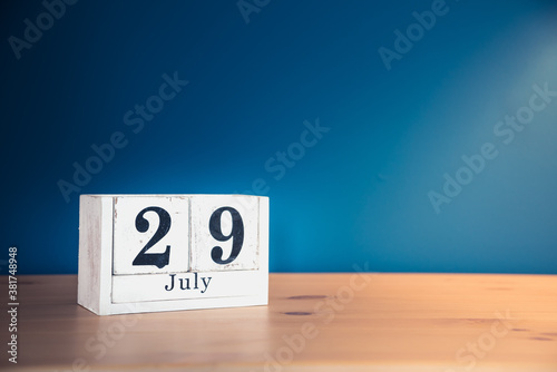 July 29 - white calendar blocks on wooden table against vintage blue background