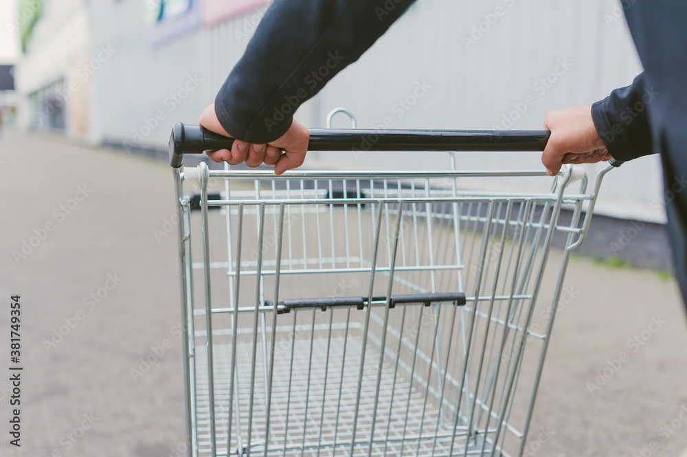 Guy with a supermarket trolley in his hands.