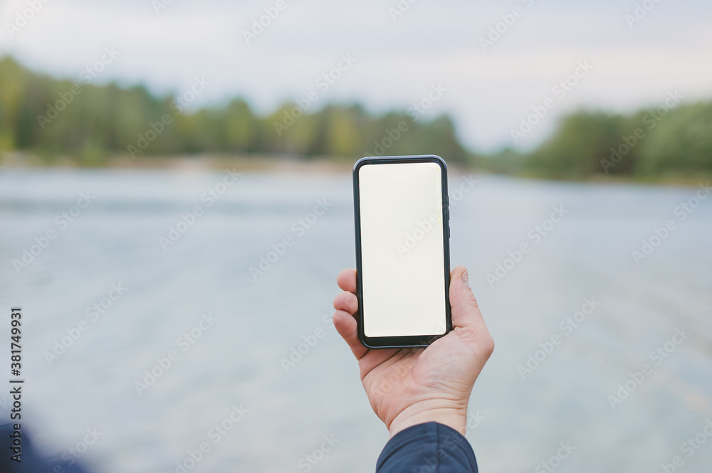 Mock-up technology. Man holds a smartphone in his hands close-up.