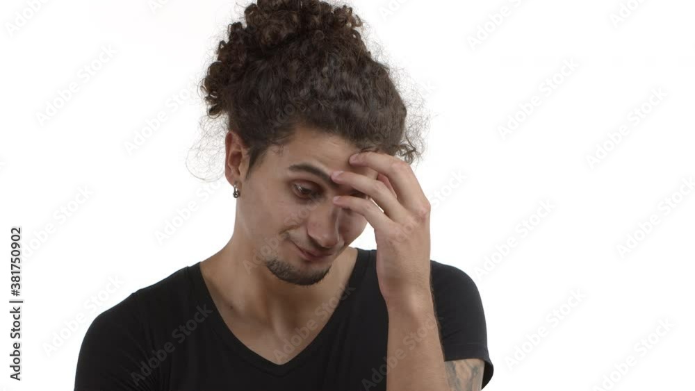 Close-up of handsome hispanic young man with beard and curly combed hair looking annoyed, facepalm and shaking head, disapprove something very bad, standing over white background Close-up of handsome hispanic young man with beard and curly combed hair looking annoyed, facepalm and shaking head, disapprove something very bad, standing over white background
