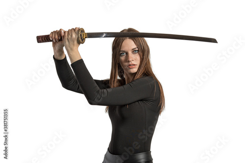 isolate a long haired woman with a Japanese katana sword in a fighting stance holds a sword over her head