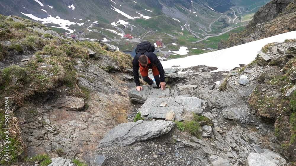 Young man hiking, climbing in the mountains, slow motion Young man hiking, climbing in the mountains, slow motion