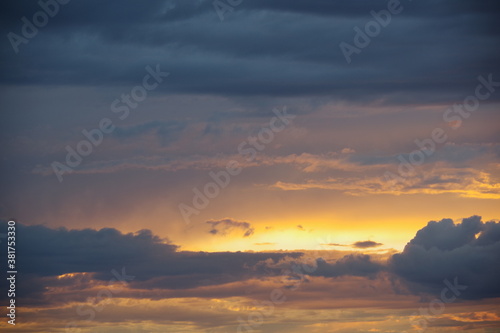 Dark storm clouds with colorful reflections of the setting sun.  Scenic storm clouds lit by the last rays of the sunset.