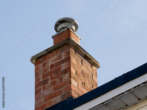a brick residential gas furnace chimney with a flue liner and rain cap