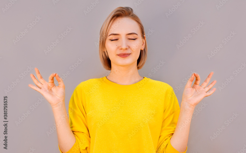 Restful peaceful blonde female feels relaxed, stands in lotus pose, tries to concentrate or to be focused, closes eyes, enjoys silence, tries to find balance. Calm atmosphere and meditation Restful peaceful blonde female feels relaxed, stands in lotus pose, tries to concentrate or to be focused, closes eyes, enjoys silence, tries to find balance. Calm atmosphere and meditation