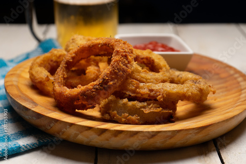 Onion rings with ketchup on white background