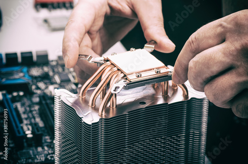 computer repair, the master installs the cooler into the computer photo