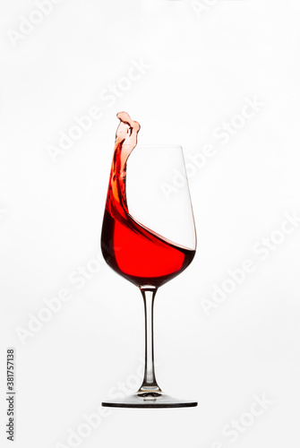splashing red wine from glass on white background