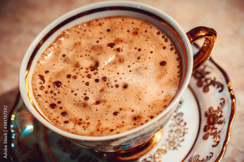 beautiful gold Cup of Cappuccino Coffee on the table beautiful gold Cup of Cappuccino Coffee on the table