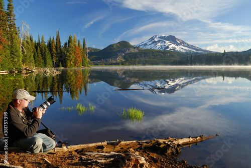 Photographer on shore of calm Sparks Lake with South Sister mountain