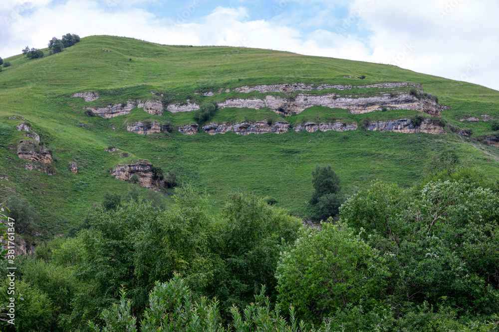 Obraz premium Mountain landscape with blue sky. Panoramic view of green hills.