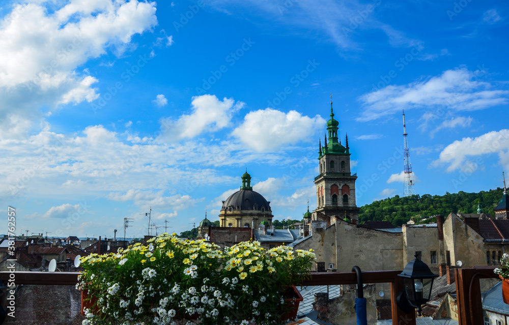 Tall bell tower of Dormition Church and the dome of Dominican Church above the old houses in the center of Lviv, Ukraine 